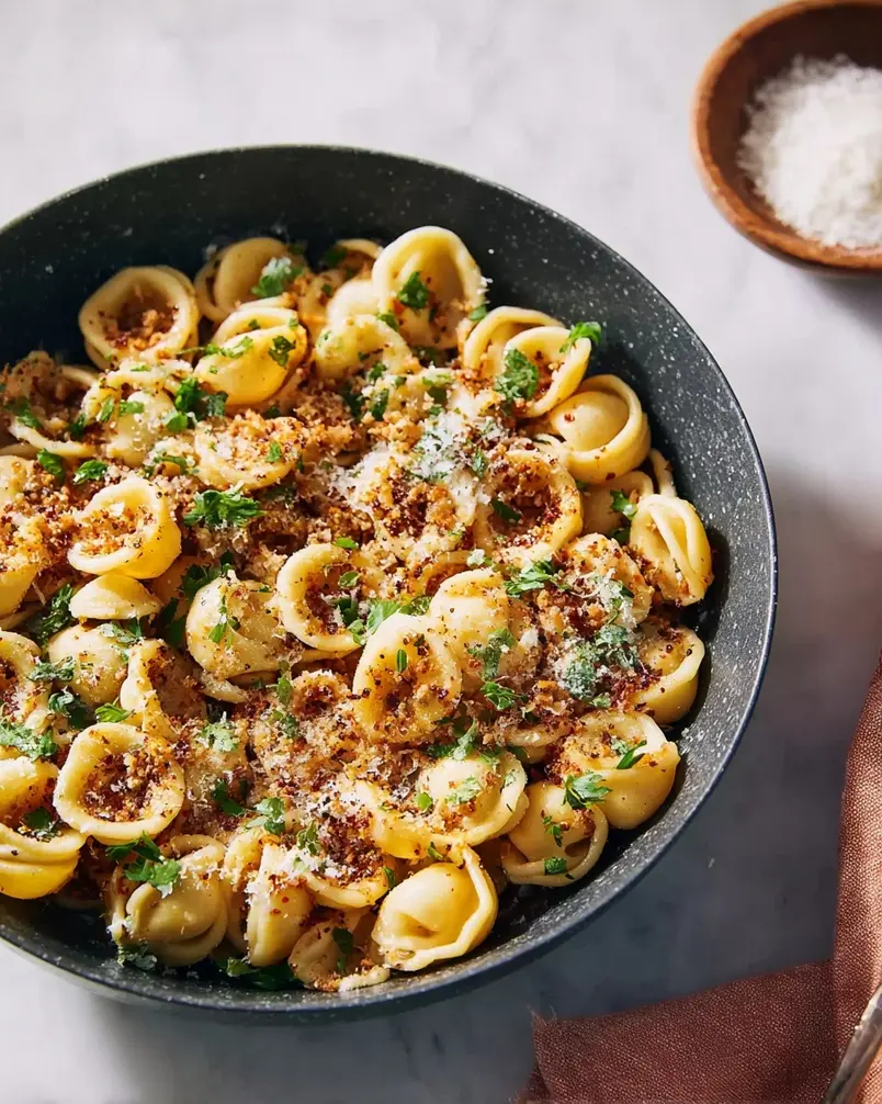 One Pan Orecchiette Pasta 2 Tender orecchiette pasta cooking in a flavorful sauce with vegetables in a large pan.